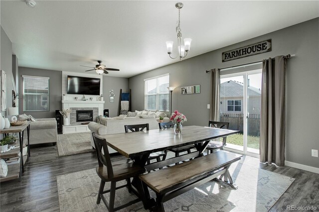 975 Alta St, Lochbuie, CO 80603 - dining area featuring dark wood-type flooring, healthy amount of natural light, ceiling fan, and a fireplace