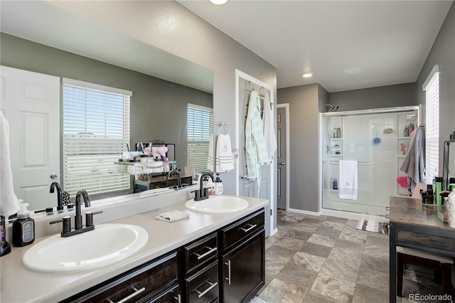 975 Alta St, Lochbuie, CO 80603 - bathroom featuring a stall shower, double vanity, healthy amount of natural light, and recessed lighting