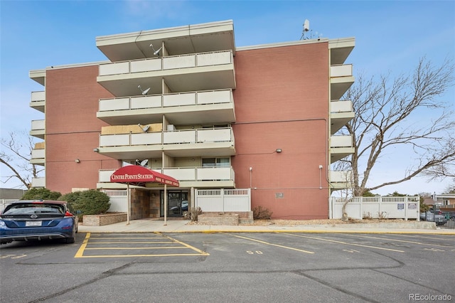 view of property featuring uncovered parking and fence