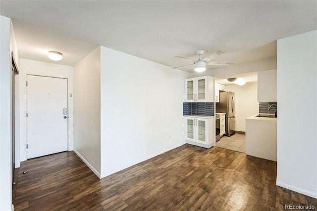 interior space with glass insert cabinets, white cabinetry, stainless steel appliances, and dark wood finished floors