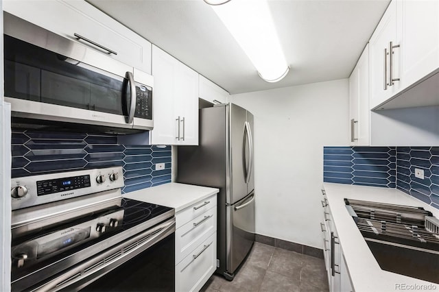 kitchen featuring stainless steel appliances, white cabinets, light countertops, and decorative backsplash