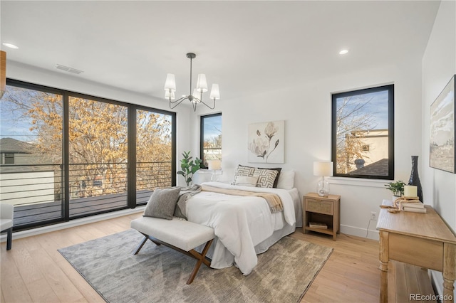 bedroom featuring light hardwood / wood-style floors and a chandelier