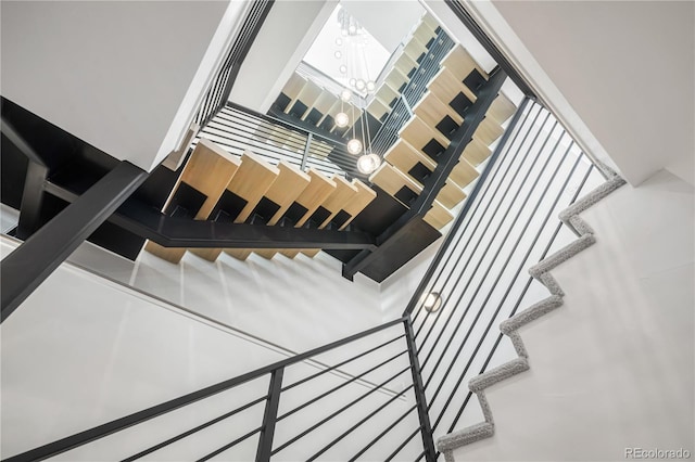 staircase featuring an inviting chandelier