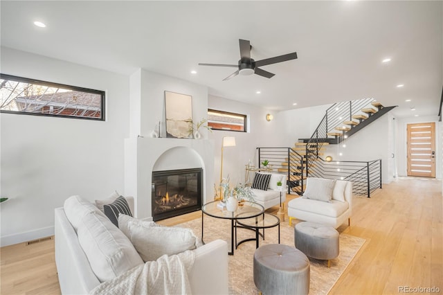 living room with light wood-type flooring and ceiling fan