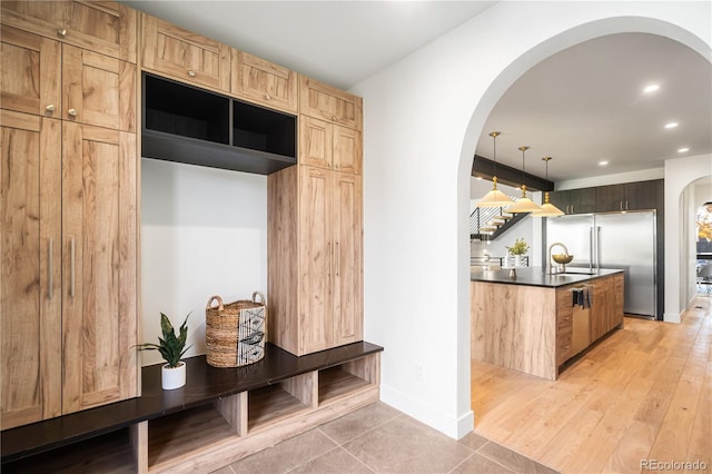 mudroom with sink and light hardwood / wood-style flooring