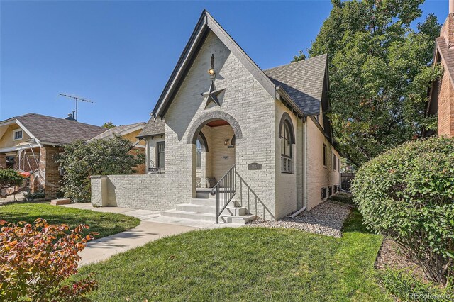 tudor-style house featuring a front lawn