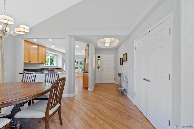 dining area featuring sink, a chandelier, and light hardwood / wood-style floors