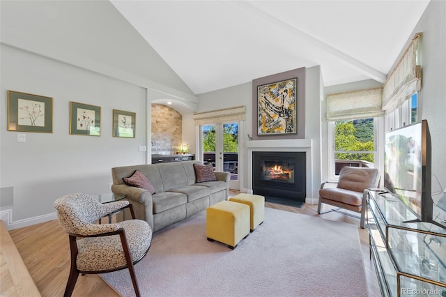 living room featuring beam ceiling, high vaulted ceiling, and light wood-type flooring