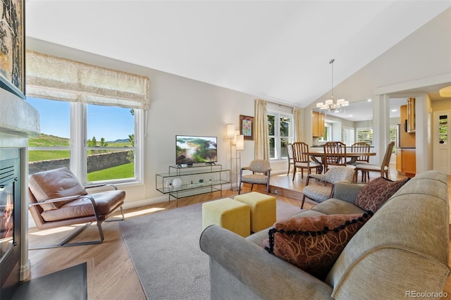 living room with a notable chandelier, hardwood / wood-style floors, and high vaulted ceiling