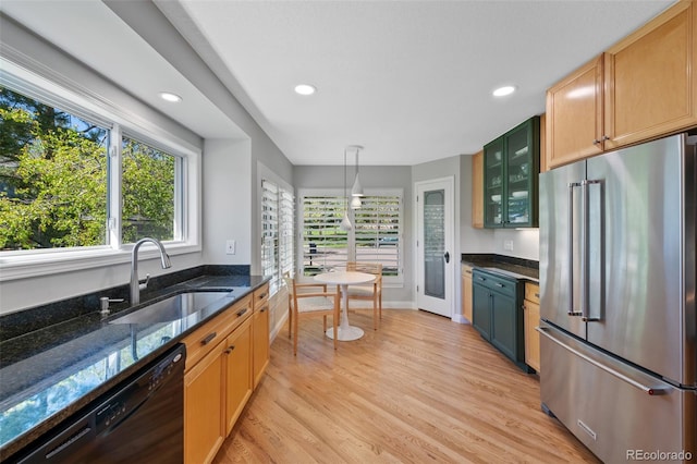 kitchen featuring sink, black dishwasher, high end refrigerator, and light hardwood / wood-style flooring