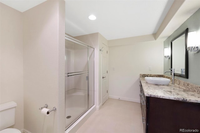 bathroom with a shower with door, tile flooring, oversized vanity, and toilet