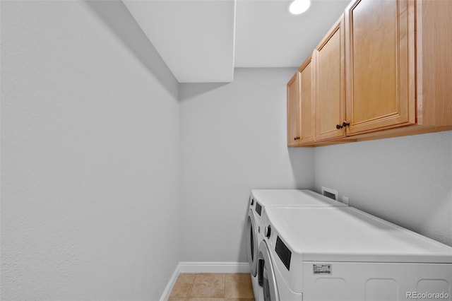 washroom with cabinets, washing machine and dryer, light tile floors, and washer hookup