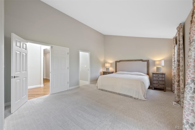 bedroom with high vaulted ceiling and light colored carpet