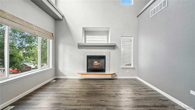 4458 Lyndenwood Pt, Highlands Ranch, CO 80130 - unfurnished living room with a fireplace and dark wood finished floors