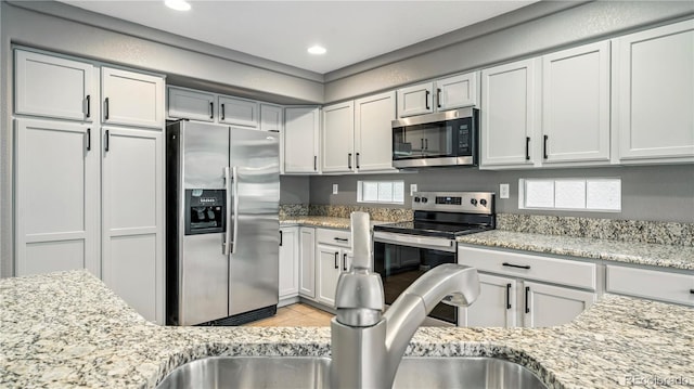 4458 Lyndenwood Pt, Highlands Ranch, CO 80130 - kitchen featuring stainless steel appliances, light tile patterned floors, light stone counters, and recessed lighting