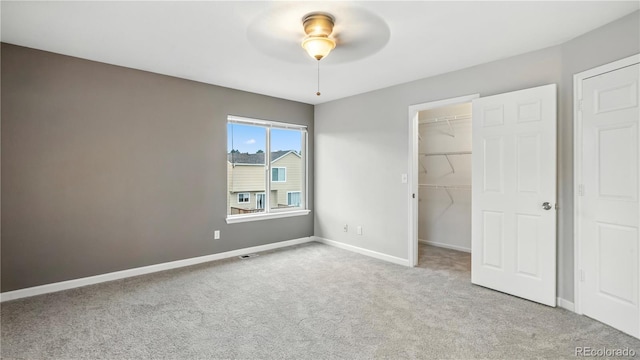 4458 Lyndenwood Pt, Highlands Ranch, CO 80130 - unfurnished bedroom featuring carpet flooring, a walk in closet, and a ceiling fan