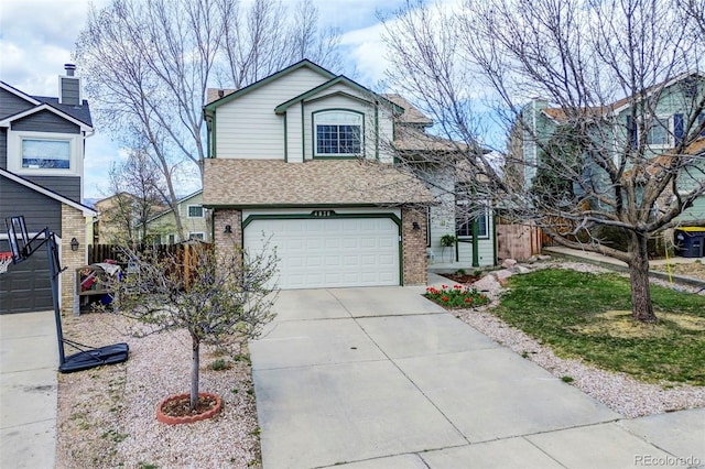 traditional home featuring brick siding, a garage, fence, and concrete driveway