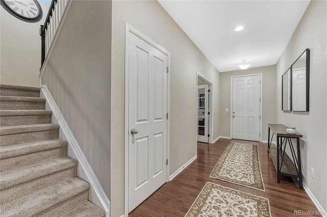 entrance foyer with dark wood finished floors, baseboards, and stairs