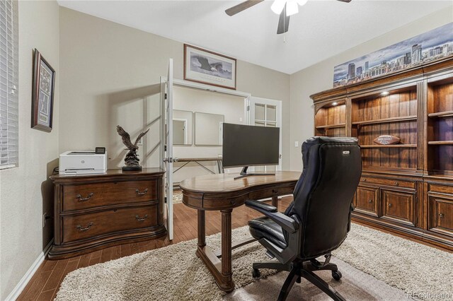 home office featuring ceiling fan, baseboards, and wood finished floors