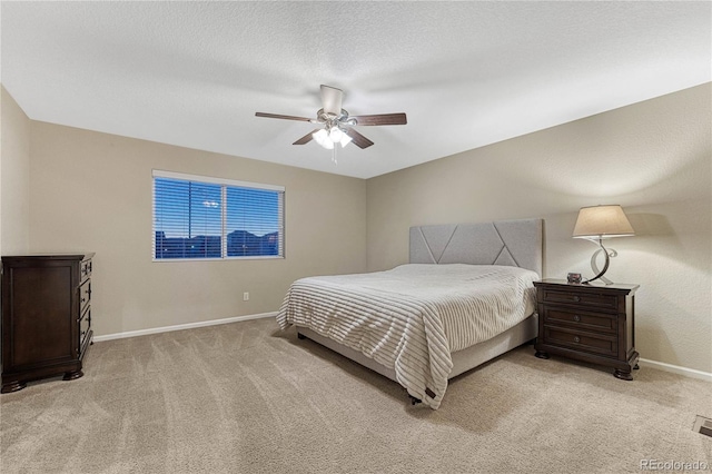 bedroom with light colored carpet, ceiling fan, and baseboards