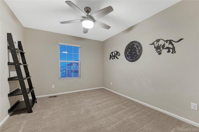 spare room with carpet floors, a ceiling fan, visible vents, and baseboards