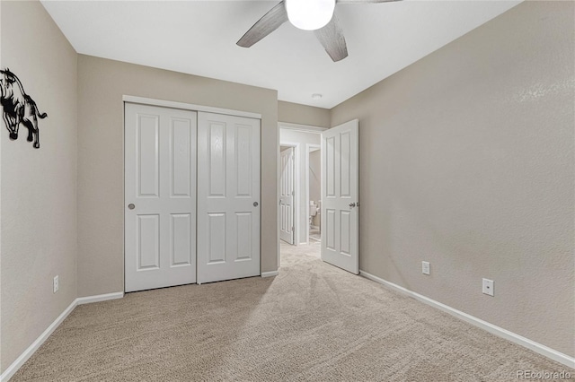 unfurnished bedroom with a closet, carpet flooring, baseboards, and a ceiling fan