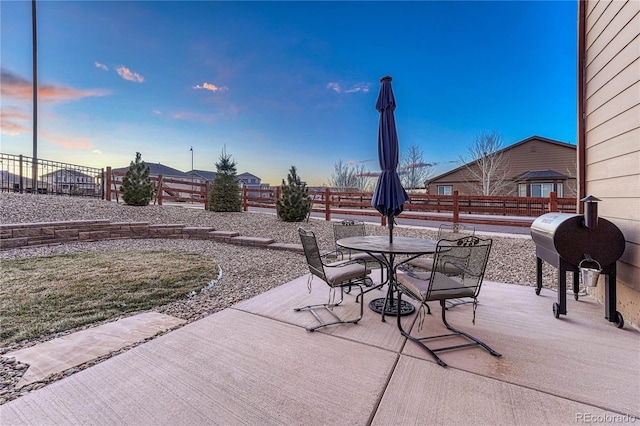 view of patio featuring outdoor dining space, a fenced backyard, and a grill