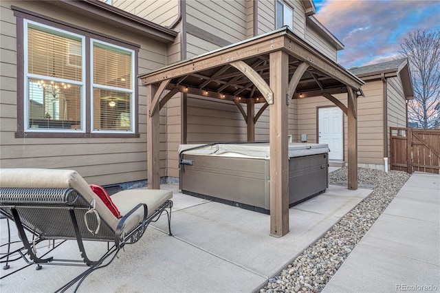 view of patio / terrace with fence, a gazebo, and a hot tub