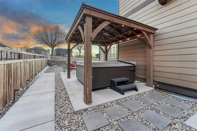 view of patio featuring a gazebo, a hot tub, and a fenced backyard