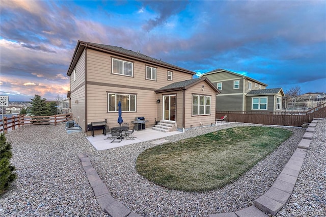 back of house featuring a fenced backyard, entry steps, a yard, and a patio