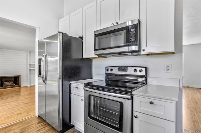 6579 Ingalls St, Arvada, CO 80003 - kitchen with appliances with stainless steel finishes, light wood-style flooring, light countertops, and white cabinetry