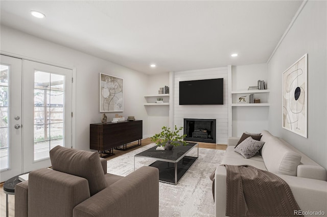 6579 Ingalls St, Arvada, CO 80003 - living area featuring wood finished floors, recessed lighting, french doors, a large fireplace, and built in features