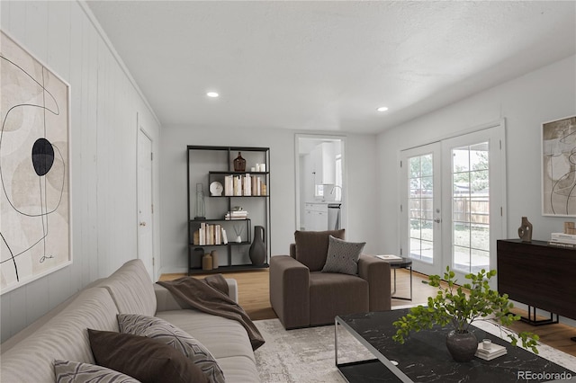 6579 Ingalls St, Arvada, CO 80003 - living room featuring french doors, light wood finished floors, recessed lighting, and wood walls