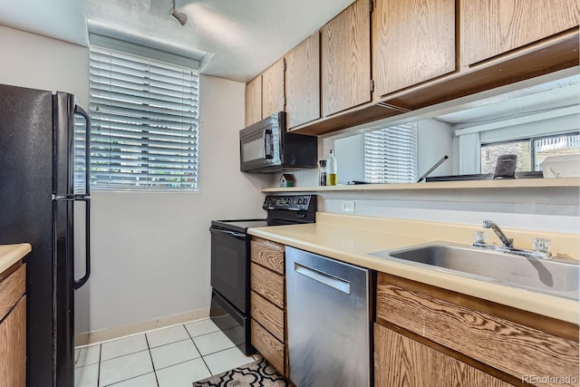 kitchen featuring light tile patterned flooring, sink, and black appliances