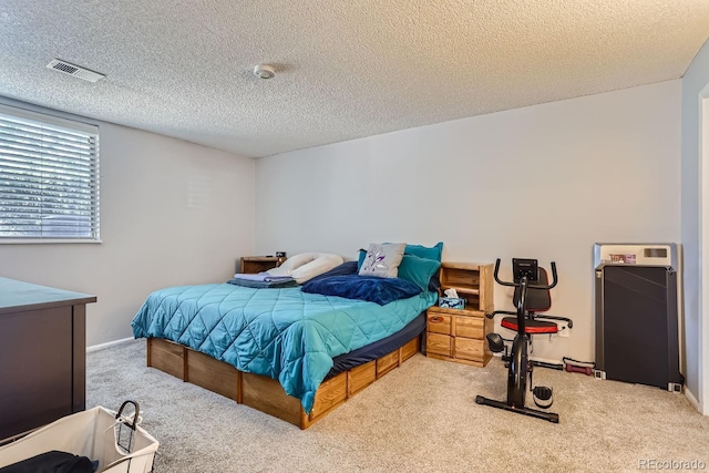 bedroom with light carpet and a textured ceiling