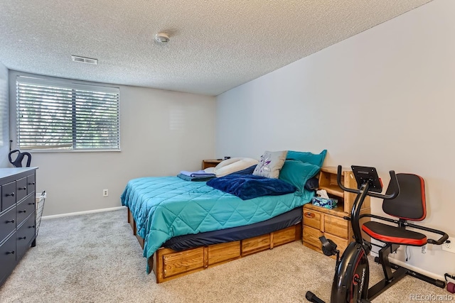 bedroom featuring light colored carpet and a textured ceiling