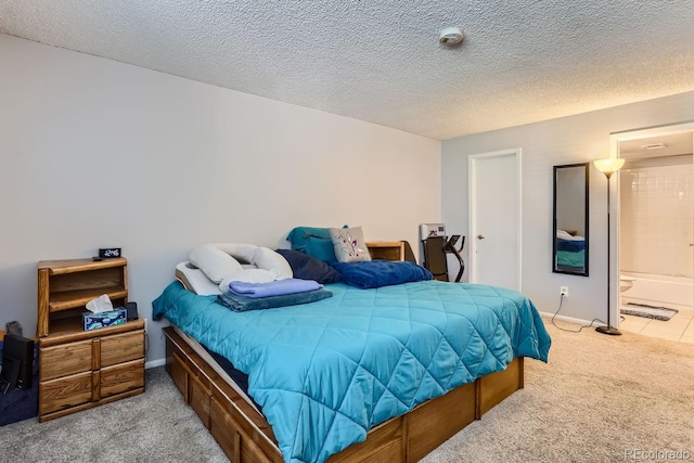 carpeted bedroom with ensuite bathroom and a textured ceiling