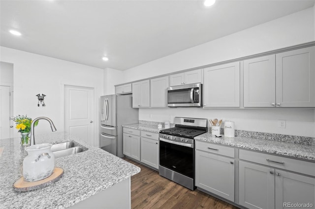 437 Thrush Pl, Johnstown, CO 80534 - kitchen with stainless steel appliances, gray cabinets, dark wood finished floors, recessed lighting, and light stone counters