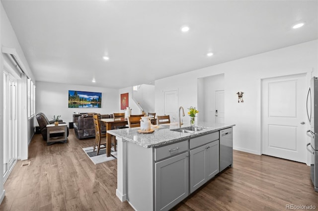 437 Thrush Pl, Johnstown, CO 80534 - kitchen featuring gray cabinetry, wood finished floors, recessed lighting, light stone countertops, and a kitchen island with sink