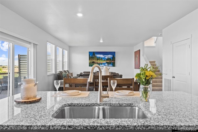 437 Thrush Pl, Johnstown, CO 80534 - kitchen with light stone countertops, open floor plan, and recessed lighting