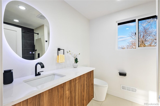 bathroom featuring tile patterned flooring, vanity, walk in shower, and toilet