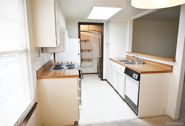 kitchen featuring electric range, white cabinets, dishwasher, light floors, and a sink