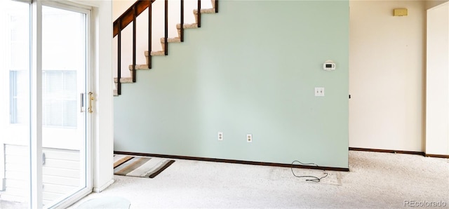 interior space featuring carpet, stairway, and baseboards