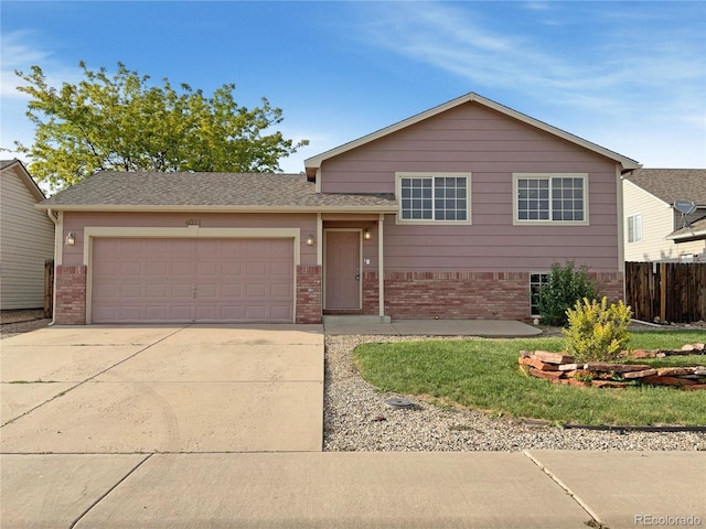 4011 W 28th Street Rd, Greeley, CO 80634 - split level home with brick siding, a garage, and concrete driveway