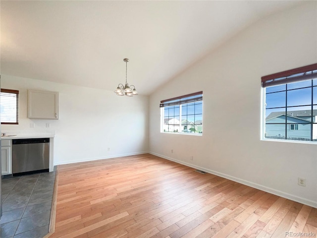 4011 W 28th Street Rd, Greeley, CO 80634 - unfurnished dining area featuring a chandelier, light wood-style flooring, and high vaulted ceiling