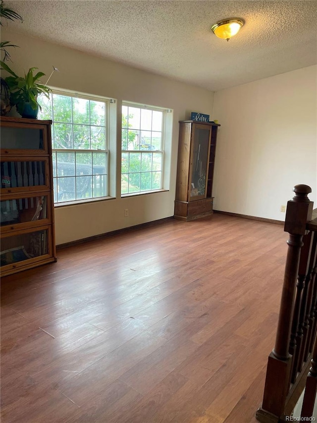 47904 Dartmouth Ave, Bennett, CO 80102 - spare room featuring a textured ceiling, wood finished floors, and baseboards