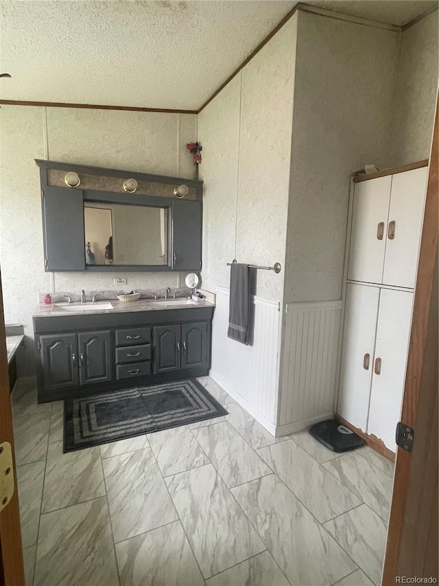 47904 Dartmouth Ave, Bennett, CO 80102 - full bath featuring double vanity, marble finish flooring, a decorative wall, and a textured ceiling
