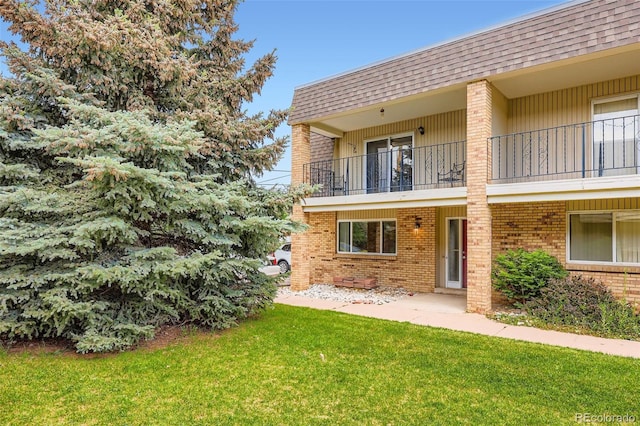6727 S Race St, Centennial, CO 80122 - exterior space featuring brick siding, a balcony, roof with shingles, a lawn, and mansard roof