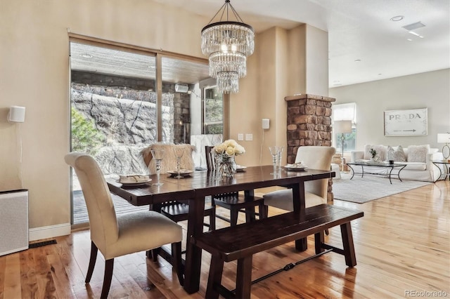 dining area with visible vents, radiator heating unit, an inviting chandelier, wood finished floors, and baseboards