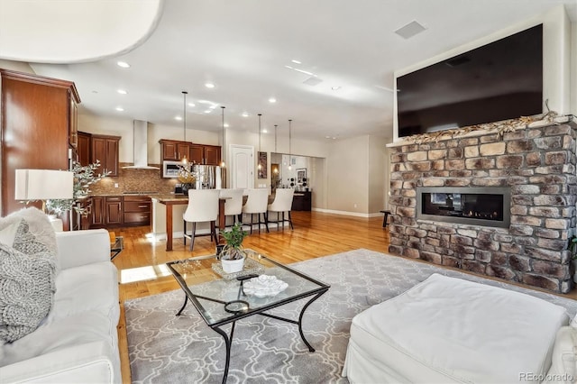 6875 Northstar Ct, Castle Rock, CO 80108 - living area featuring light wood-type flooring, recessed lighting, a brick fireplace, and baseboards